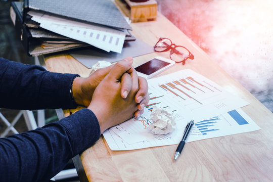 Dismal.businessman In Blue Shirt Worried Work With Chaotic On Office Desk ,document, Graph Data Paper On Table,Sunset Light Background