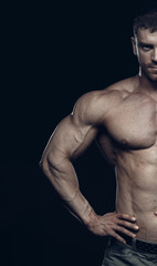 Obraz na płótnie Canvas Male bodybuilder, fitness model trains in the gym