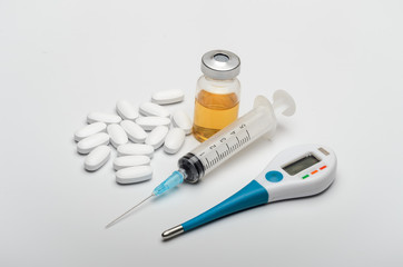Drugs with a thermometer, tablets and a syringe for injections from viral diseases