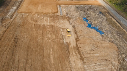 Construction of a new road in the forest area. Aerial view construction road place. Construction machinery for the construction of a road in the forest.