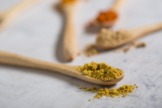 Different spices in wooden spoons