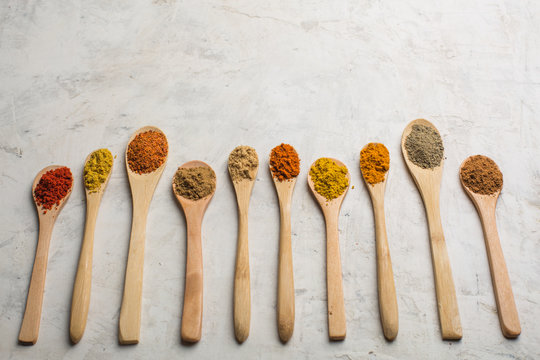 Different spices in wooden spoons