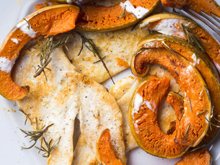 Grilled chicken breast with pumpkin slices baked with rosemary, drizzled with yogurt sauce.