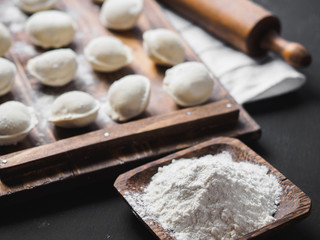 Frozen raw dumplings on the wooden desk on black background
