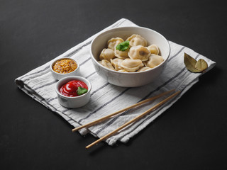 Dumplings on plate at wooden desk on black background