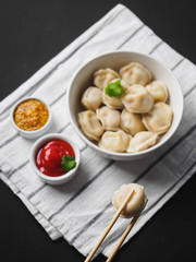 Dumplings on plate at wooden desk on black background
