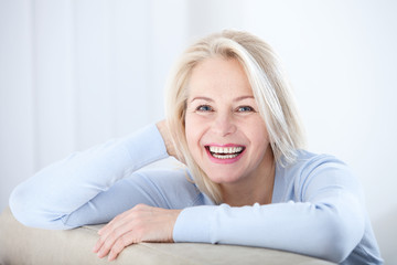 Active beautiful middle-aged woman smiling friendly and looking in camera. Woman's face closeup....