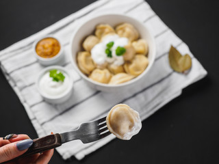 Dumplings on plate at wooden desk on black background