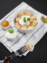 Dumplings on plate at wooden desk on black background