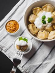 Dumplings on plate at wooden desk on black background