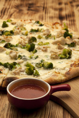 Pizza with chicken and broccoli on wooden board served with ketchup