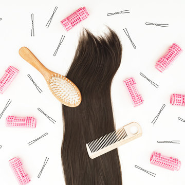 Beauty composition with hairdresser tools for hair styling and curlers on white background. Flat lay, top view