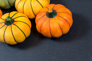 Little colored pumpkins on a black background