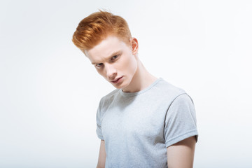  Life prospects. Ambitious ginger nice guy posing in t shirt while looking angry and overcoming problem