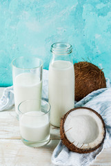 Vegan alternative food, coconut non-dairy milk on light blue background, copy space