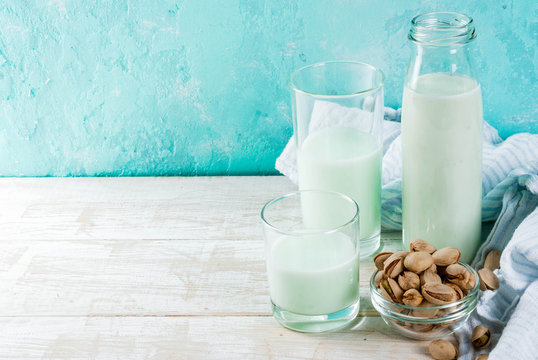 Vegan alternative food, pistachio non-dairy milk on light blue background, copy space