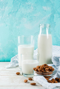 Vegan alternative food, almond non-dairy milk on light blue background, copy space