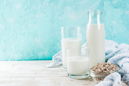 Vegan alternative food, oats non-dairy milk on light blue background, copy space