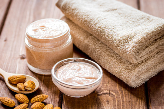 spa concept with almond nuts and scrub on wooden background