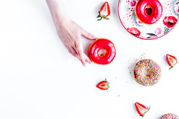 strawberry donut in hand on white background top view space for 