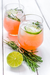 fitness cocktail in glass with lime and rosemary on white table 