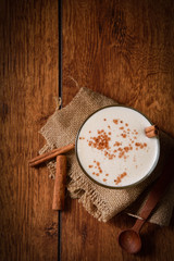 Eggnog houmemade with cinnamon and kakao for Christmas and winter holidays or wooden broun backgrounds