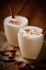 Eggnog houmemade with cinnamon and kakao for Christmas and winter holidays or wooden broun backgrounds