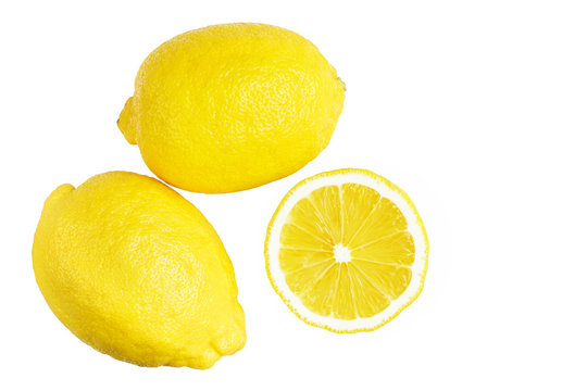 Two whole yellow ripe lemon fruit and one round slice, isolated on a white background, top view