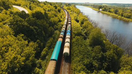 Freight train with cisterns and containers on the railway. Aerial view Container Freight Train, Locomotive in the countryside, Railway and highway.