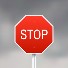 Red stop sign on gray sky background