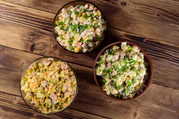 Set of festive mayonnaise salads on wooden table. Top view