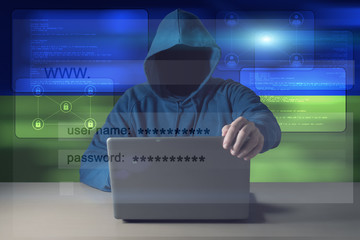 Hacker sitting in front of a laptop on background of digital flag of Ukraine. Cyber Security concept.