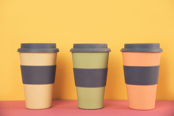 Take away coffee cups on colorful paper background.