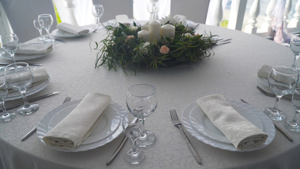 Banquet decorated table, with cutlery. Wedding decor in the banquet hall.Serving of a festive table, plate, napkin, knife, fork. Table setting decoration. Romantic Dinner or other events.