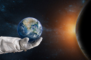 Earth in the hand of astronaut. Earth Day concept. Elements of this image furnished by NASA.