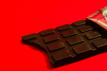 かじった痕のある板チョコレート　赤色背景