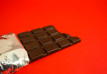 かじった痕のある板チョコレート　赤色背景
