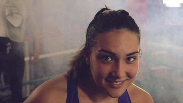 Portrait of cute female boxer smiling looking camera slow motion retro style closeup