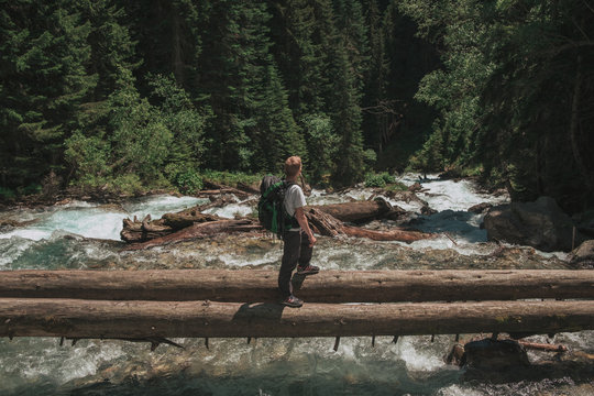 hiker man crossing the river to reach the other side