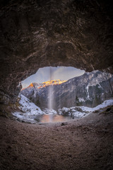Waterfall Goriuda and sun shines on mountains in Italian alps