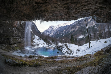 Fototapeta na wymiar Waterfall Goriuda with turquoise lake in snow covered Italian aps