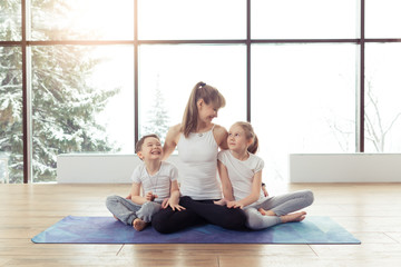 Young family of mother and children son and daughter are engaged in fitness, yoga, exercise at gym. Healthy sport lifestyle concept