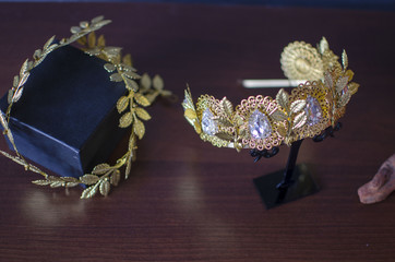 Gold color fashion crown with green gemstones. Golden diadema royalty jewelry