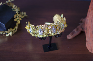 Gold color fashion crown with green gemstones. Golden diadema royalty jewelry