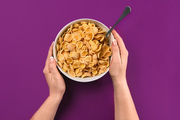 Food, healthy eating, people and diet concept - close up of woman eating muesli for breakfast over purple background