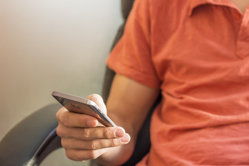 Young businessman using mobile smart phone sit on armchair at office