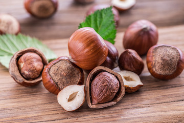 Hazelnuts and hazelnut leaves on the wooden table.