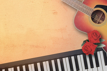 Spanish acoustic folk guitar and piano keyboard with beautiful two red rose symbol of love in the...