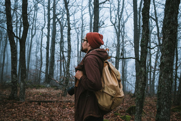 Naklejka premium man walking on a dark path through a spooky forest