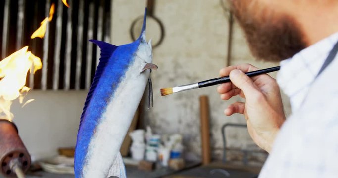 Craftsman polishing fish sculpture 